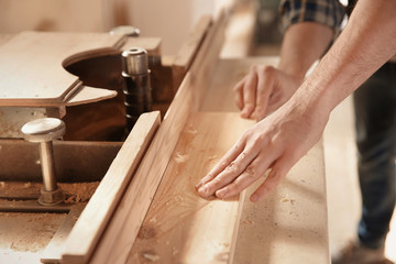 Carpenter working with timber strip in shop