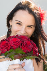 charming bride smiling with her bouquet of wedding roses