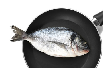Frying pan with fresh dorado fish on white background