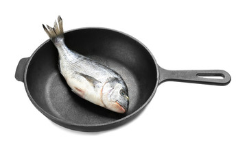 Frying pan with fresh dorado fish on white background