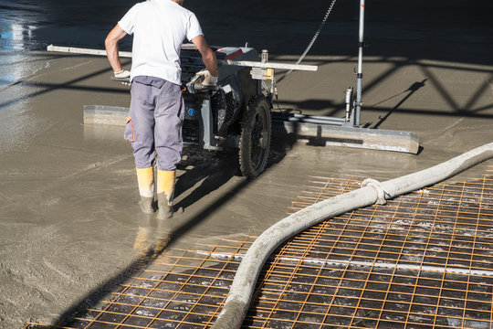 Construction Worker With Concrete Floor Laser Leveling Screed Machine