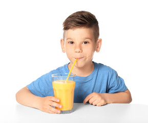 Cute little boy drinking juice on white background