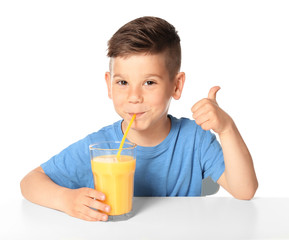 Cute little boy drinking juice on white background