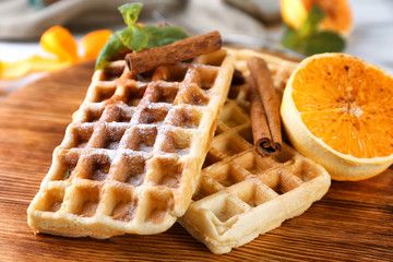Delicious cinnamon waffles with orange, closeup
