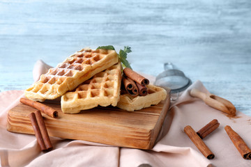 Delicious cinnamon waffles with mint leaves on table