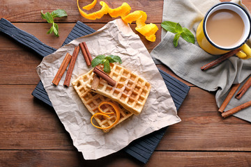 Delicious cinnamon waffles with orange zest on table