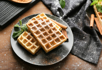 Delicious cinnamon waffles with mint leaves on table