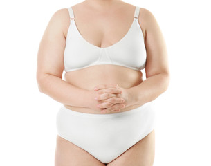 Overweight young woman in underwear on white background. Diet concept