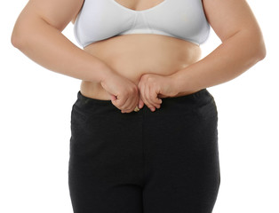 Overweight woman in bra and trousers on white background. Diet concept