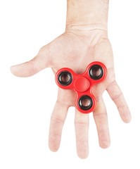 Red fidget spinner in hand isolated on white background