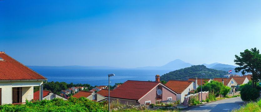 Traditional european Mediterranean architectural style, streets & houses with terracotta roofs, surrounded by cypress, palm, olive, pine trees, on coast azure sea. Location of the prestigious estates