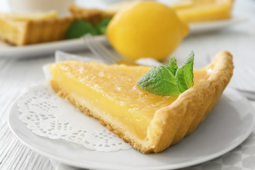 Piece of lemon tart with mint on plate