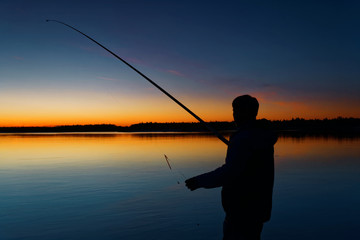 Fisherman on sunset background. Russia, Yamal.