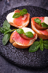 Crostini with salmon, mozarella, tomato and basil