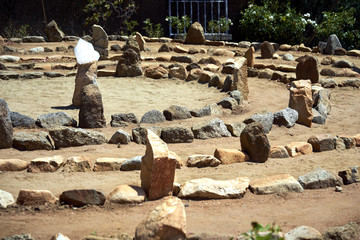 Large stone and sand labyrinth bathed in mid-day sunlight; crystal center stone to gather your thoughts