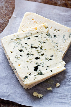 Two slices of blue cheese on white parchment paper 