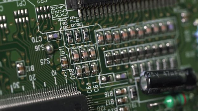 Macro shot of technology background. Electronic circuit chips on PC board rotating. Shallow depth of field.