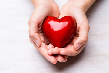 Obraz premium Red wood heart in child hands.
