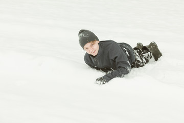 Fototapeta na wymiar Single boy playing in the snow