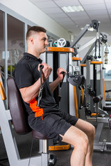 Young fit handsome man working out in gym room © kolotype