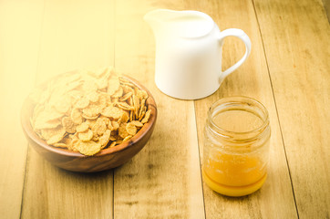 flakes, honey and a creamer on a rustic background/flakes, honey and a creamer on a rustic background. Toned