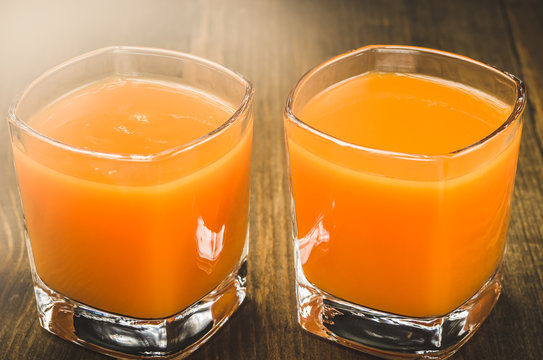 two glasses with yellow juice/two glasses with yellow juice. Toned