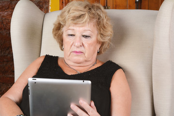 Old woman using tablet.