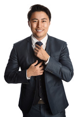 Handsome young entrepreneur with a smile standing against a white background wearing a blue suit, tie and vest. 
