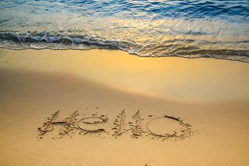 Hello message written in tropical beach sand