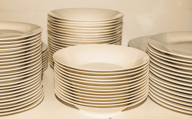 Piles of white plates in warm tones