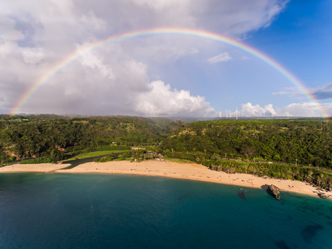 Aerial view of Waimea bay with a full rainbow on the north shore of Oahu Hawaii