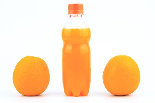 Orange juice in plastic bottle on white background with orange fruit