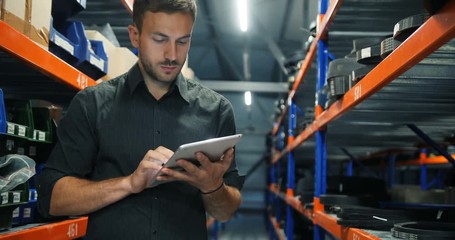 Portrait of warehouse worker checking the inventory in the warehouse - Powered by Adobe