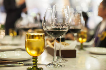 Blurry background of wine glass set up on the table in luxury dinner party.