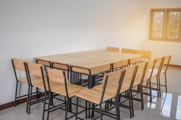 Fototapeta premium light empty classroom for lessons and training group in high school, wood table and chairs.