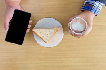 coffee and sandwich with mobile phone for breakfast of businessman wooden office desk background top view,The manager for hard working with smart phone