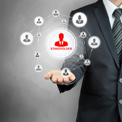 STAKEHOLDER sign connected with businesspeople icon network on businessman hand