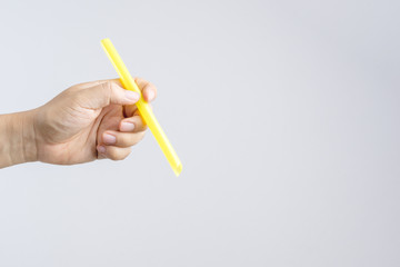 Hand holding a big or extra large drinking straw
