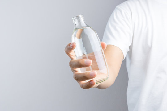 Hand holding glass water bottle