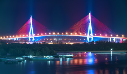 Fototapeta na wymiar Can Tho cable bridge at night shimmering colorful coupled river banks serving traffic in the Mekong Delta
