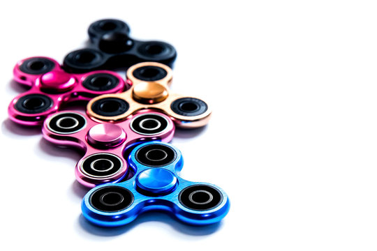 Fidget finger metal spinner, anxiety relief toy on white isolated background, copyspace. Concept relieving stress