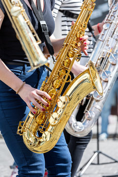 quartet of young musicians playing saxophones during street performance