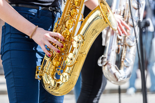 young woman playing saxophone during street fest performance