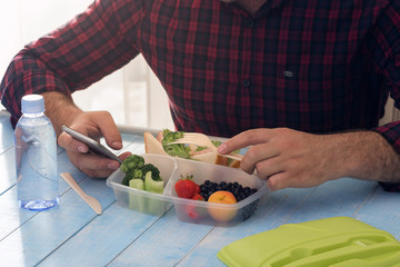 Man is having lunch healthy food sitting at wooden table