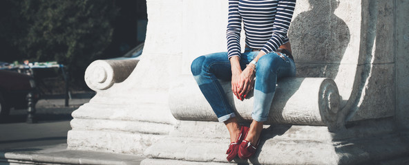 Young woman In casual clothes sitting in city park