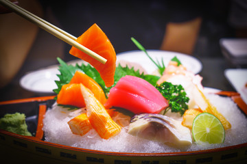 Salmon slice sashimi in chopsticks