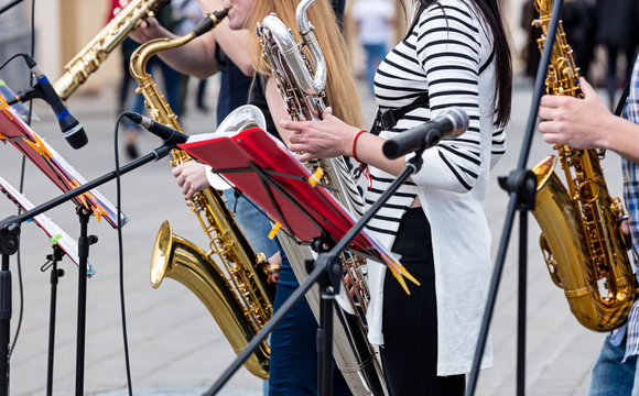 quartet of young musicians playing saxophones during outdoor performance