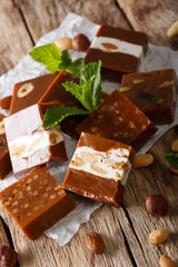 Delicious soft caramel candy with nuts close-up on parchment. vertical