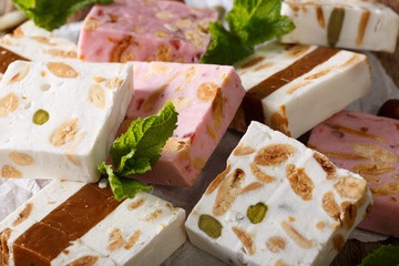 nougat with almonds and pumpkin seeds is decorated with mint macro. horizontal
