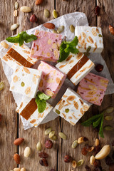Nougat with nuts and pumpkin seeds close-up on the table. Vertical top view